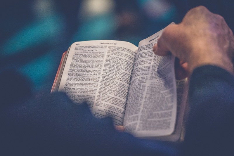 Person turning page in a Bible